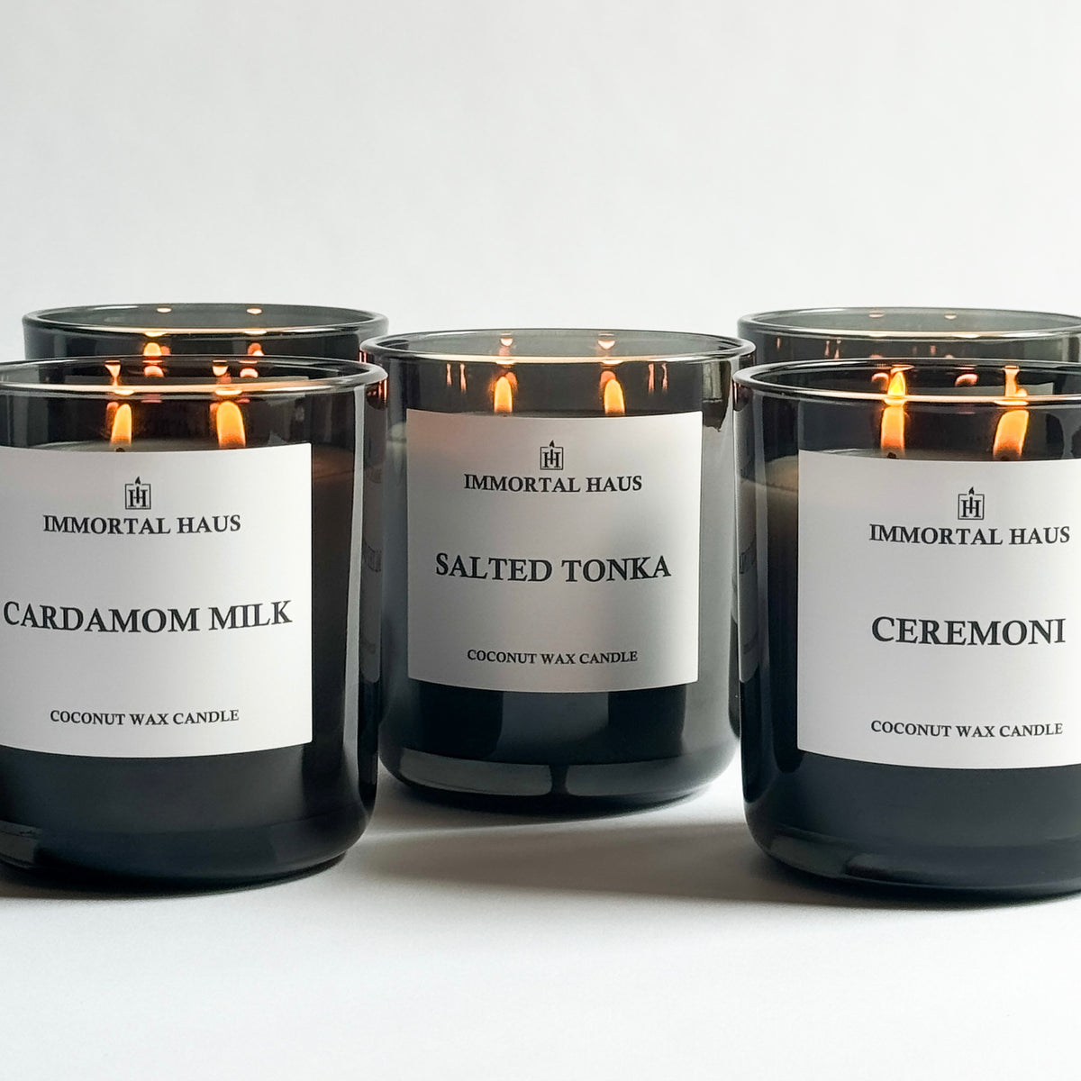 Build Your Own Candle Set – three translucent Immortal Haus luxury candles glowing in smoked glass vessels.