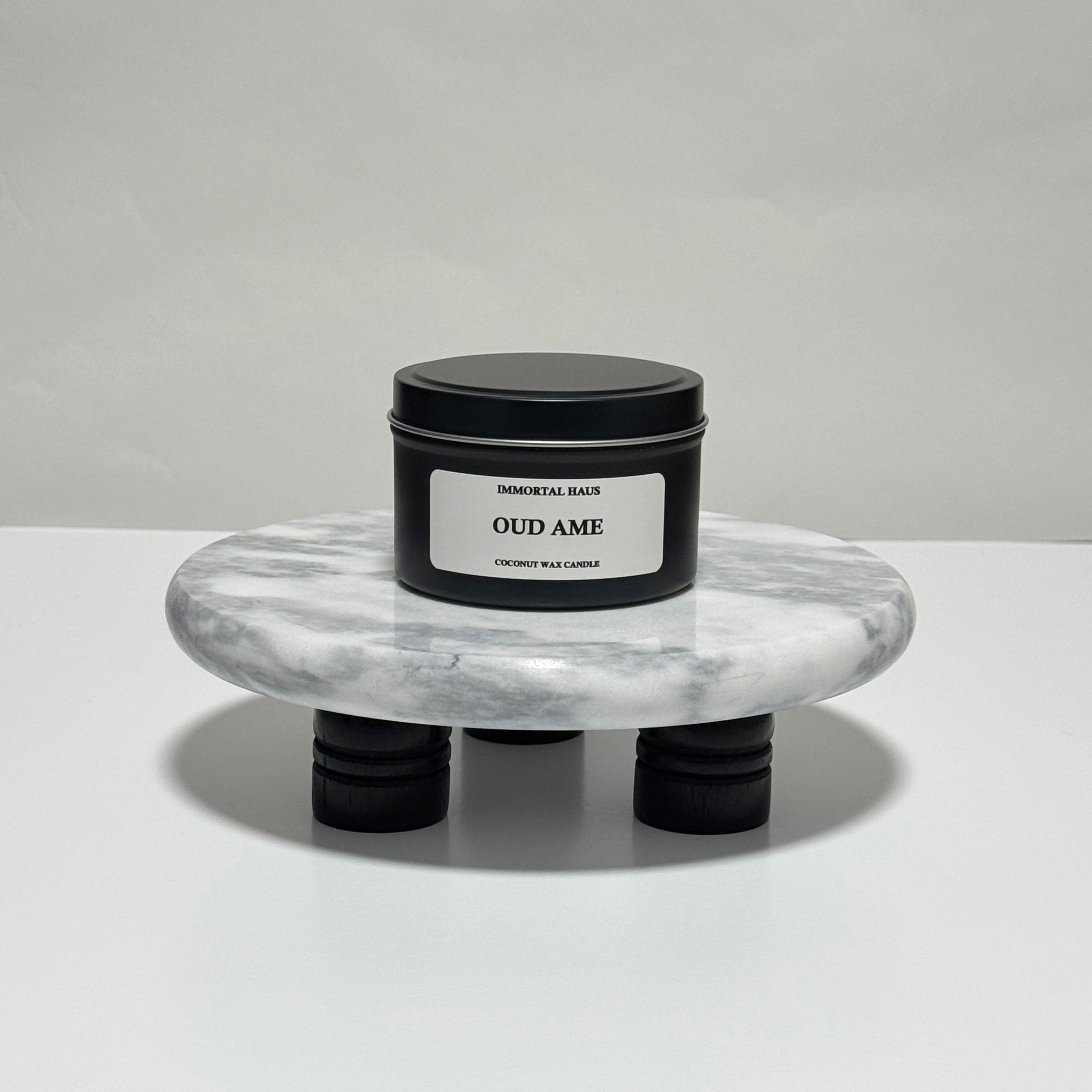Oud Ame travel candle in charcoal gray tin, oud and amber scent, 6.3 oz single wick